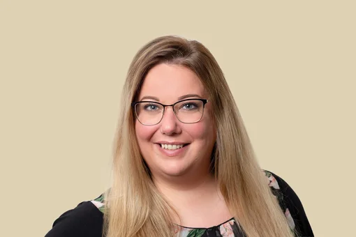 Christiane Arends, Office Manager Professional headshot of Christiane Arends, an office manager, wearing glasses and smiling against a brown background.