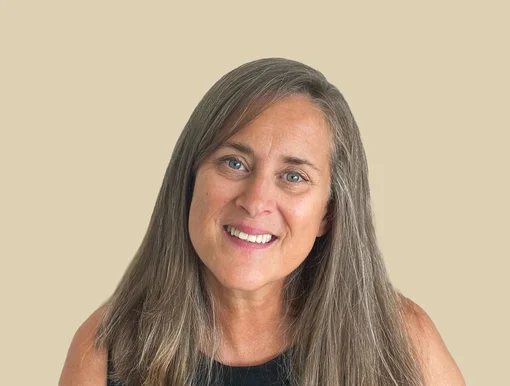 Professional headshot of Dana Gentry, a case manager, with long hair smiling against a brown background.