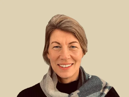 Professional headshot of Judy Neudorf, a case manager, wearing a scarf and smiling against a brown background.