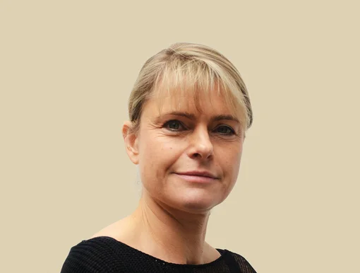 Professional headshot of Pia Ritter, an office manager, smiling against a brown background.
